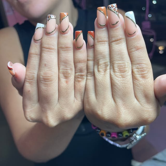 Manicura elegante con diseño dorado y blanco